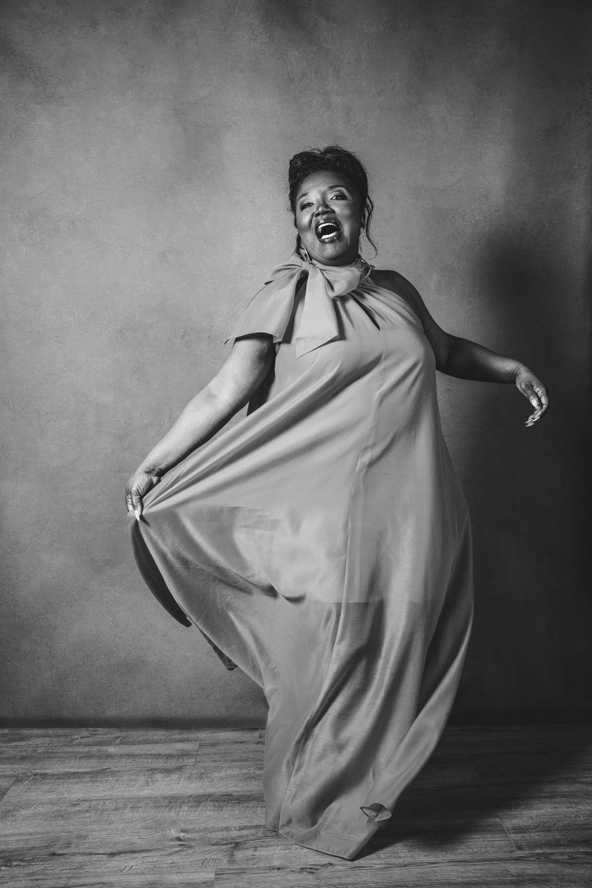 A full-length portrait of a woman in a flowing dress