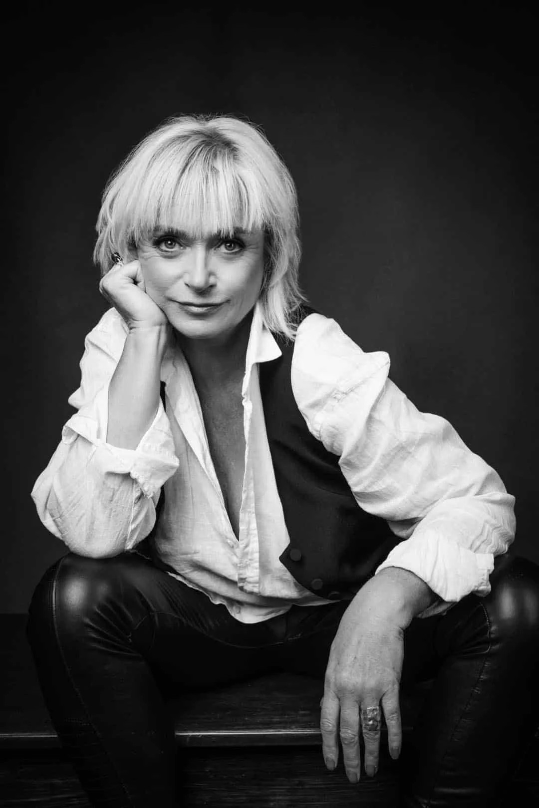 A woman in a white shirt in her studio portrait